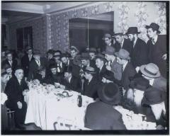 Picture of Rabbi Eliezer Silver Speaking (Seated) Surrounded by a Large Group of Men
